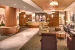 Warm hospital reception lobby with seating and timber ceiling