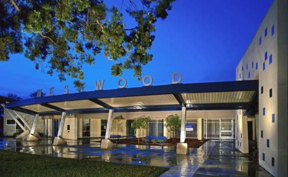 School entrance canopy with WESTWOOD signage at dusk