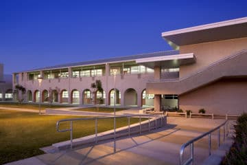 Modern campus building lit at dusk